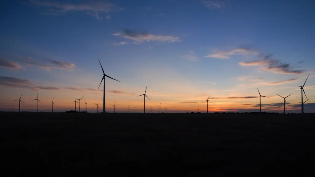 Windkraftanlagen auf einem Feld in der Dämmerung, weite Landschaftsansicht, kühles Licht
